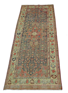 A vintage handmade Persian runner rug featuring a traditional floral pattern in red and blue tones.