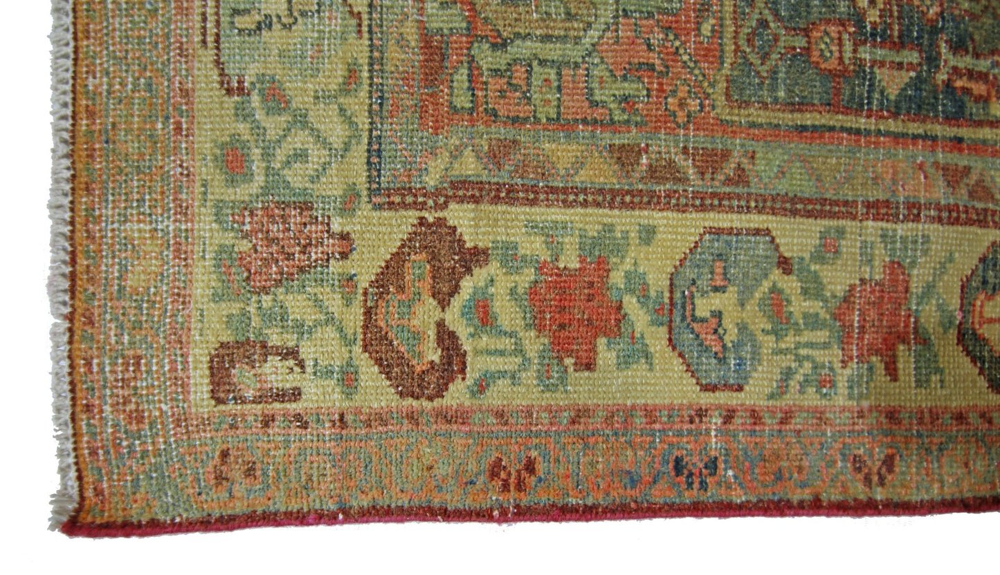 A close-up of a vintage handmade Persian rug featuring intricate floral patterns in muted tones.