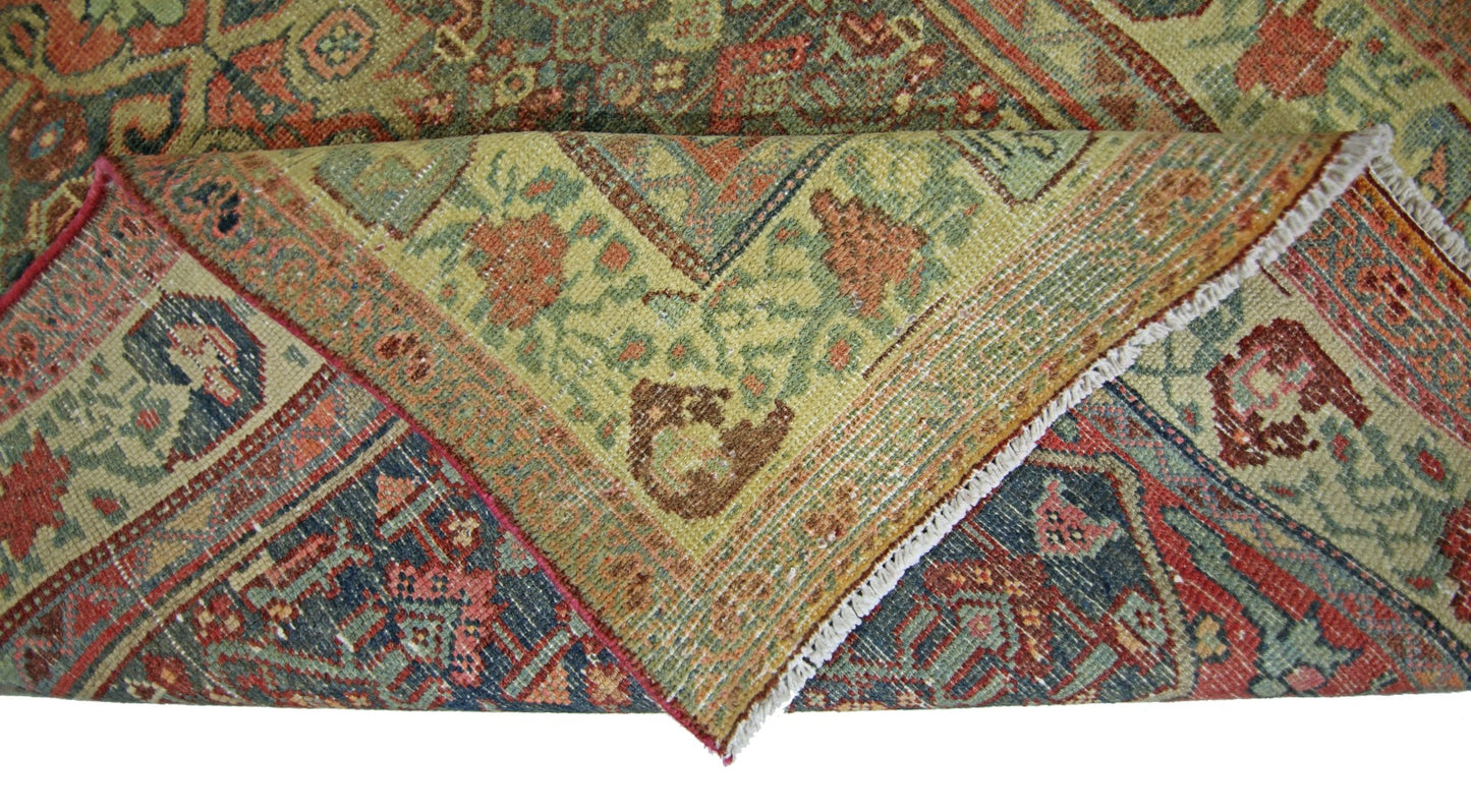 A folded vintage Persian rug featuring intricate floral patterns in red, blue, and green tones.