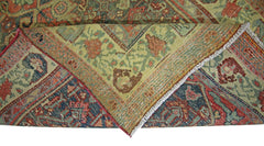 A folded vintage Persian rug featuring intricate floral patterns in red, blue, and green tones.