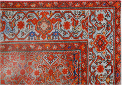 A vintage handmade Persian rug featuring intricate geometric patterns in red, blue, and grey.