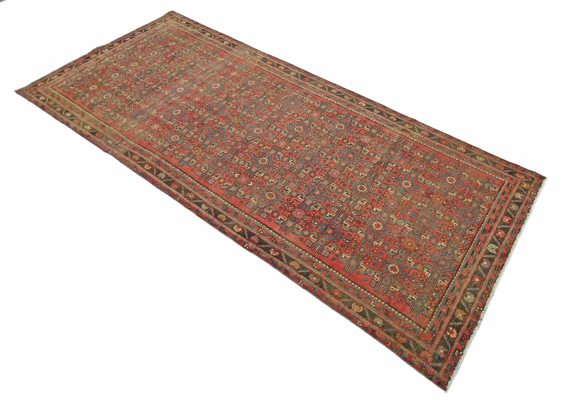 A rectangular vintage Persian rug featuring a detailed geometric pattern in red and blue tones.