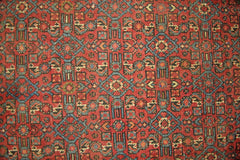 A vintage Persian rug featuring a geometric pattern in shades of red, blue, and cream.