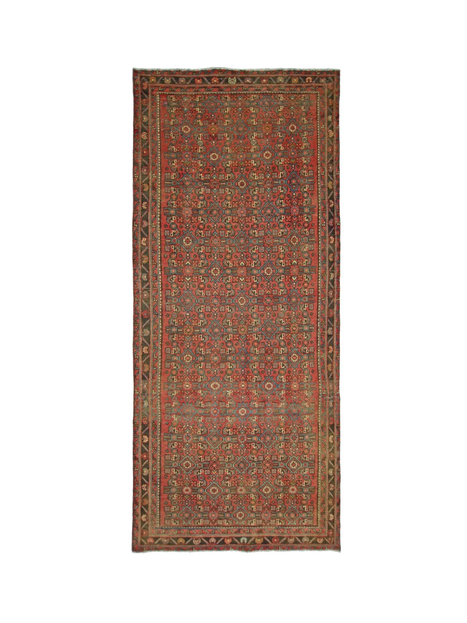 A rectangular vintage Persian rug featuring a geometric pattern in red, blue, and tan tones.