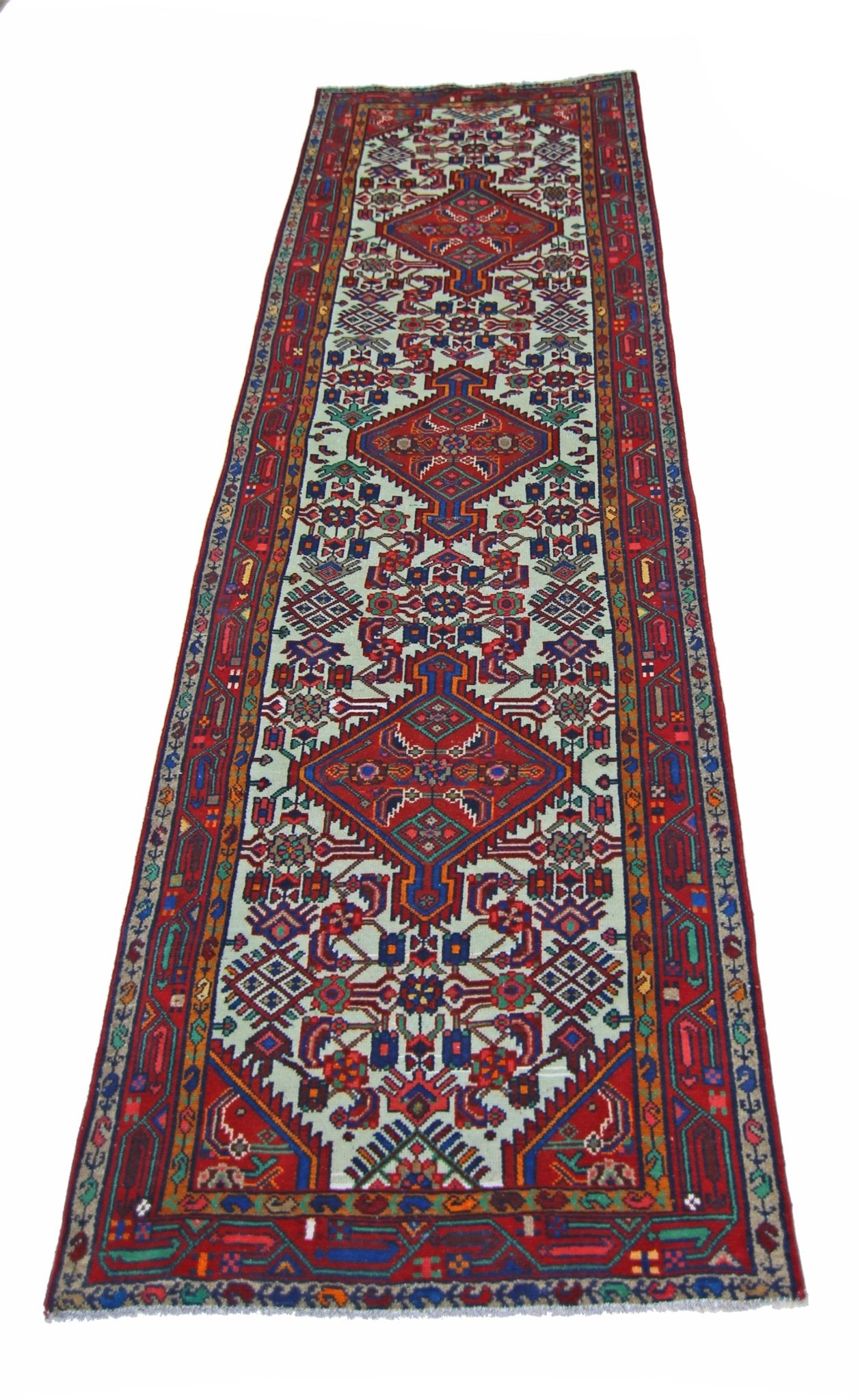 A vintage Persian Hamadan runner featuring intricate geometric patterns in red and blue tones.