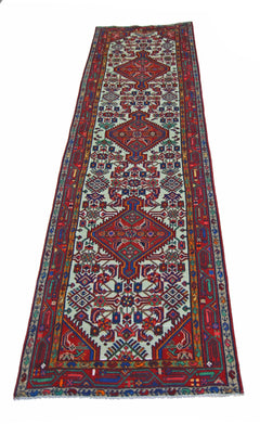 A vintage Persian Hamadan runner featuring intricate geometric patterns in red and blue tones.