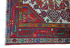 A vintage Persian Hamadan runner featuring intricate geometric patterns in red, blue, and green.