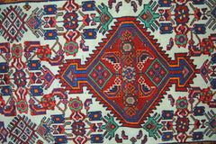 A vintage Persian Hamadan runner featuring a central red diamond medallion on a cream background.