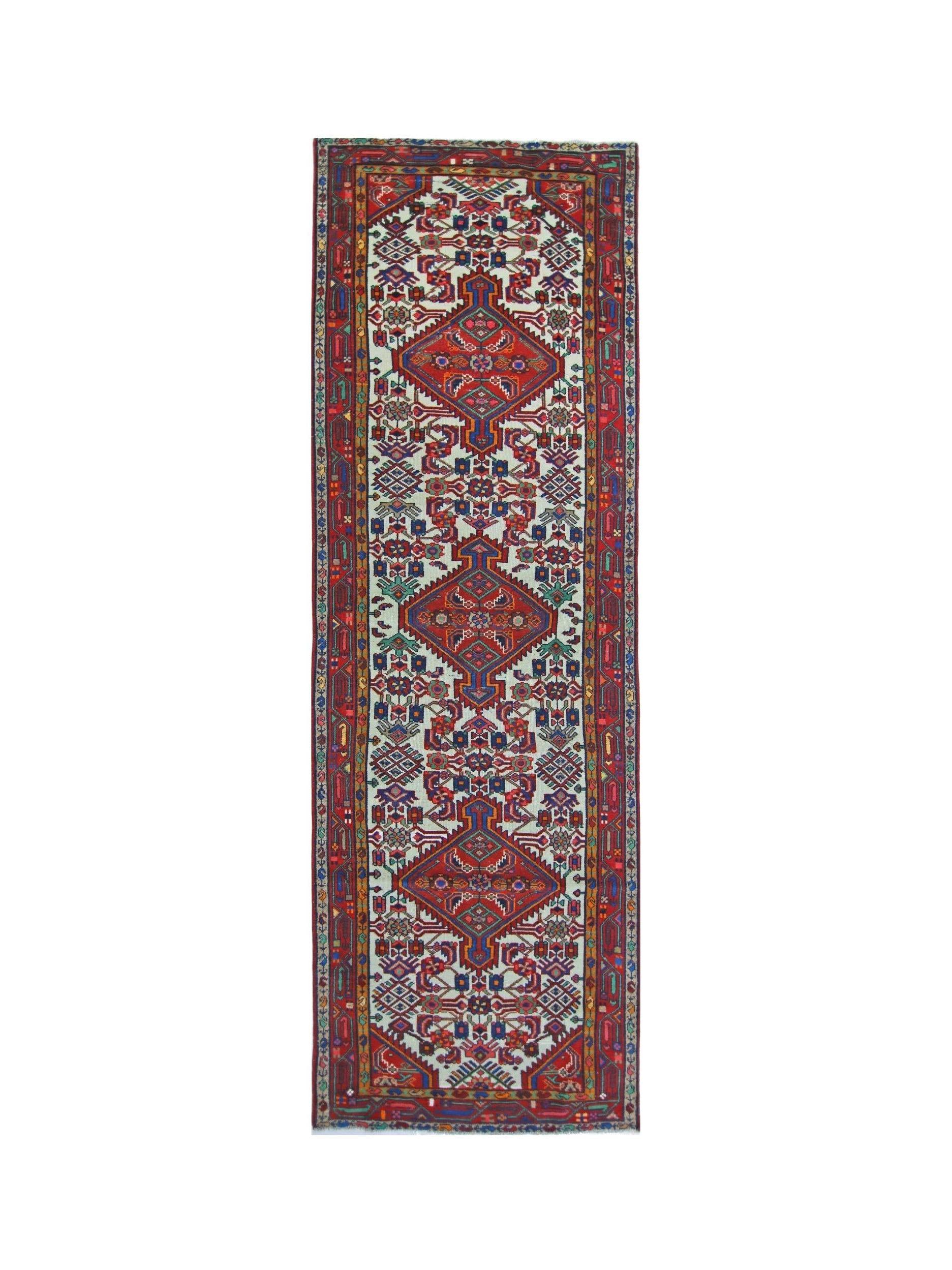 A vintage Persian Hamadan runner featuring a geometric pattern in red, blue, and cream tones.