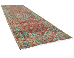 A vintage Persian Hossainabad runner rug featuring a red field with intricate floral patterns.
