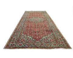 A vintage Persian Hossainabad runner rug featuring a traditional red and teal floral pattern.