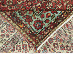 A vintage Persian Hossainabad runner featuring intricate floral patterns in red and teal.