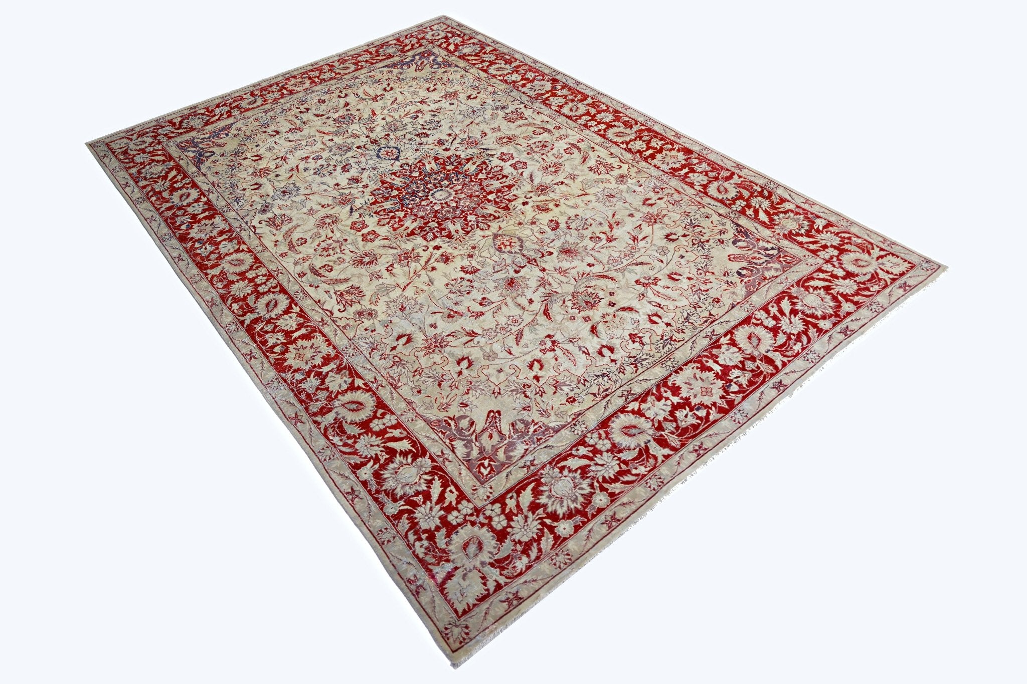 A vintage Pakistani rug featuring a central floral medallion on a cream field with a red border.
