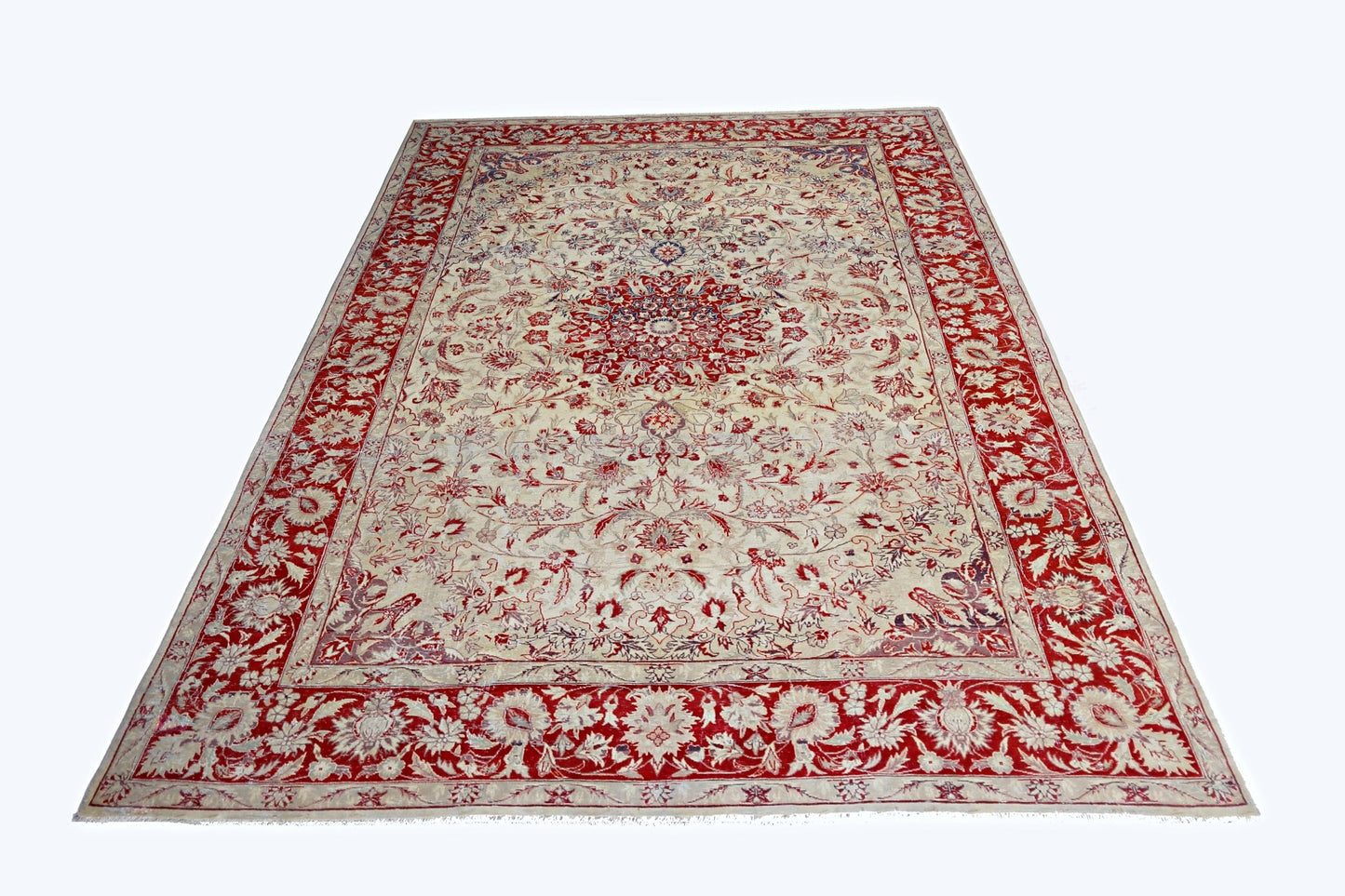 A vintage handmade Pakistani rug featuring a central floral medallion on a cream field with a red border.