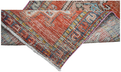 A vintage Persian Karaja runner featuring a geometric pattern in shades of red, blue, and cream.