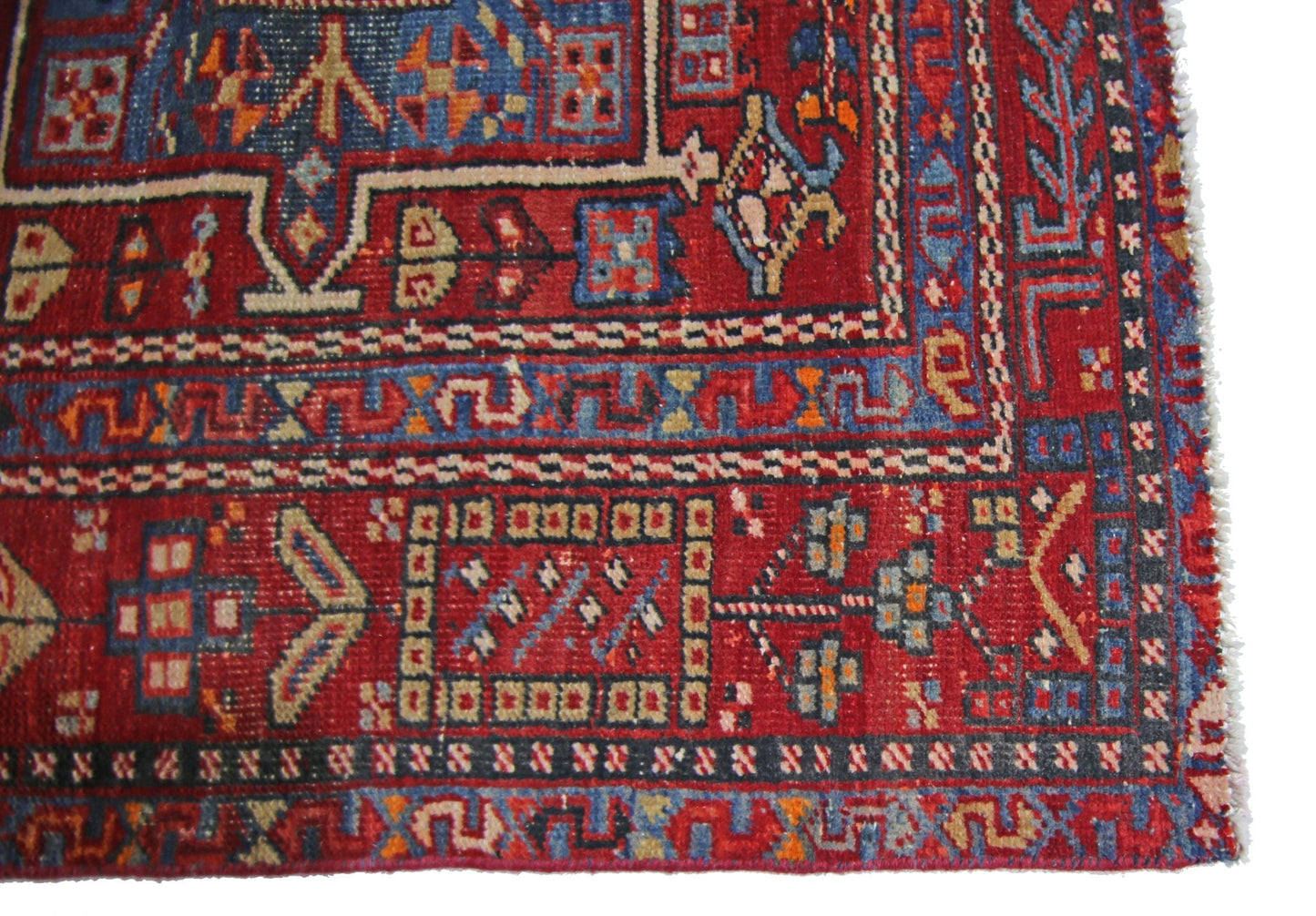 A vintage Persian Karaja runner featuring geometric patterns in red, blue, and cream wool.