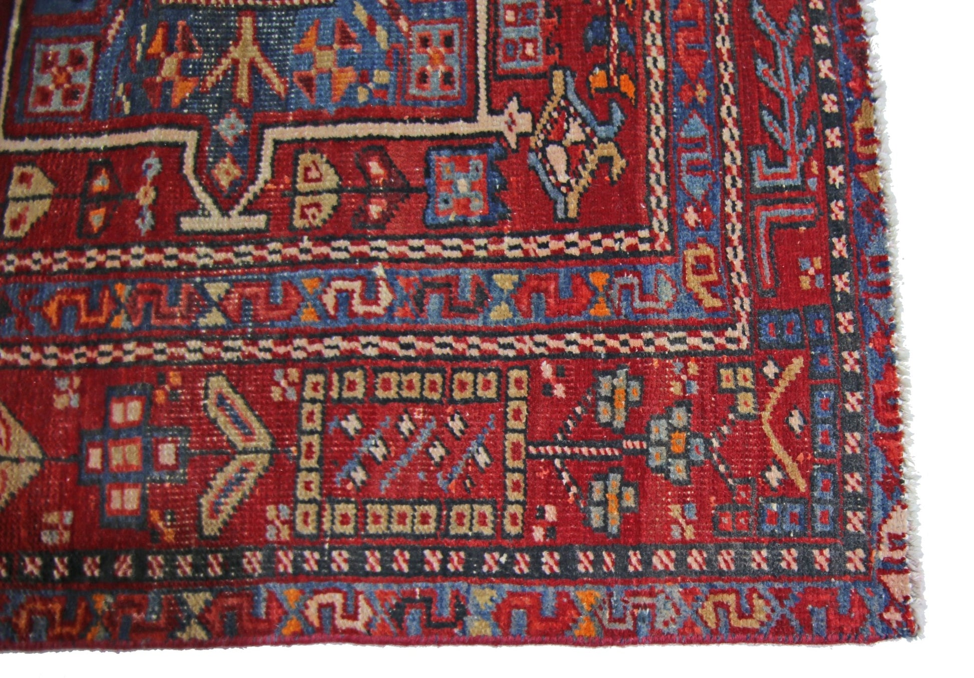 A vintage Persian Karaja runner featuring geometric patterns in red, blue, and cream wool.