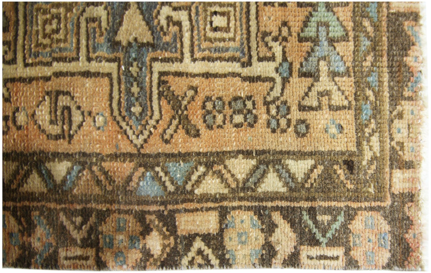 A close-up of a vintage Persian Karaja runner featuring geometric patterns in wool on cotton.