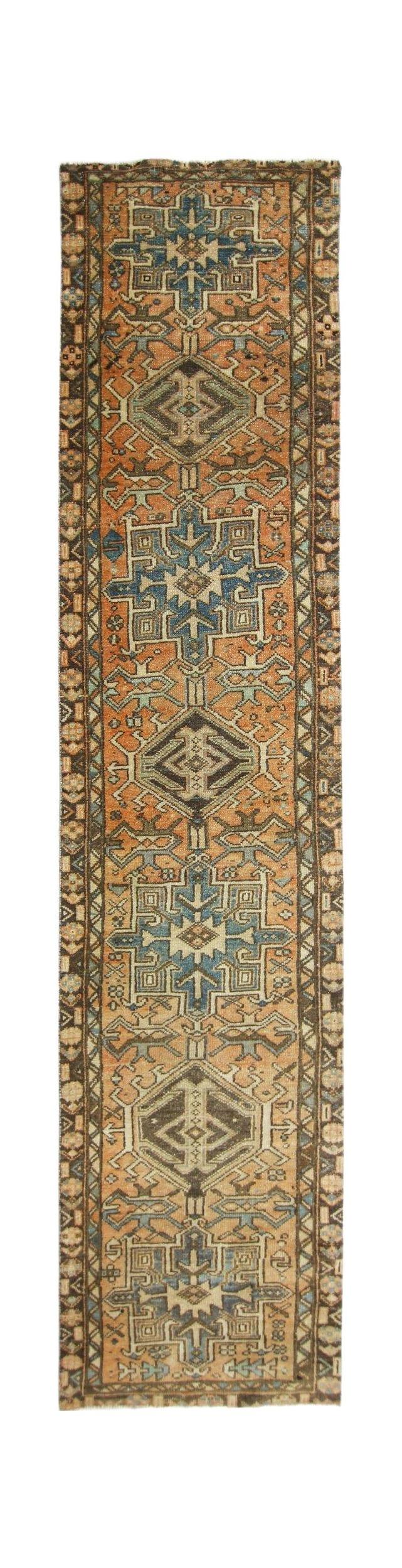 A vintage Persian Karaja runner featuring geometric medallions in blue and orange on a wool pile.