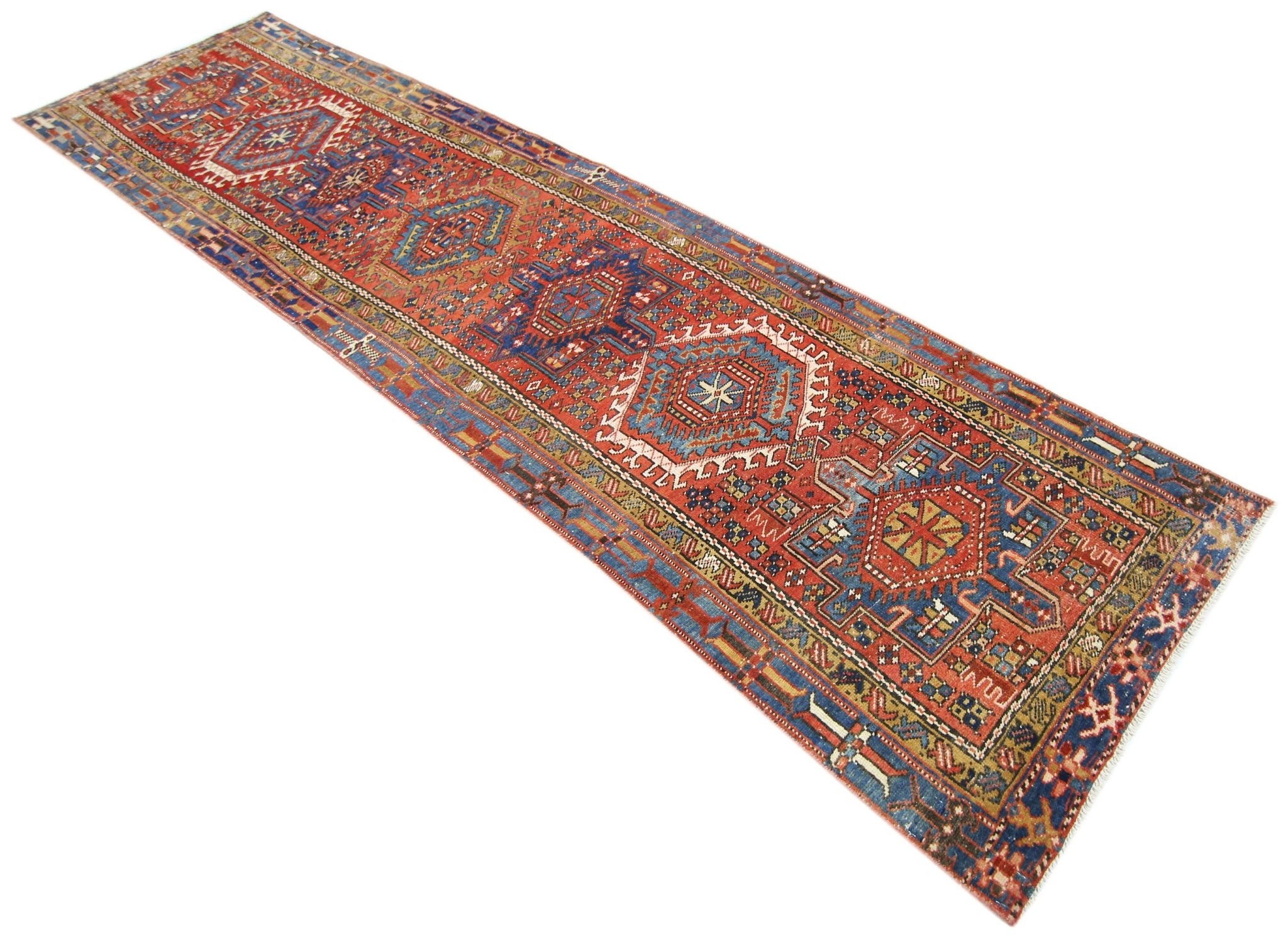 A vintage Persian Karaja runner rug featuring geometric medallions in red, blue, and cream tones.