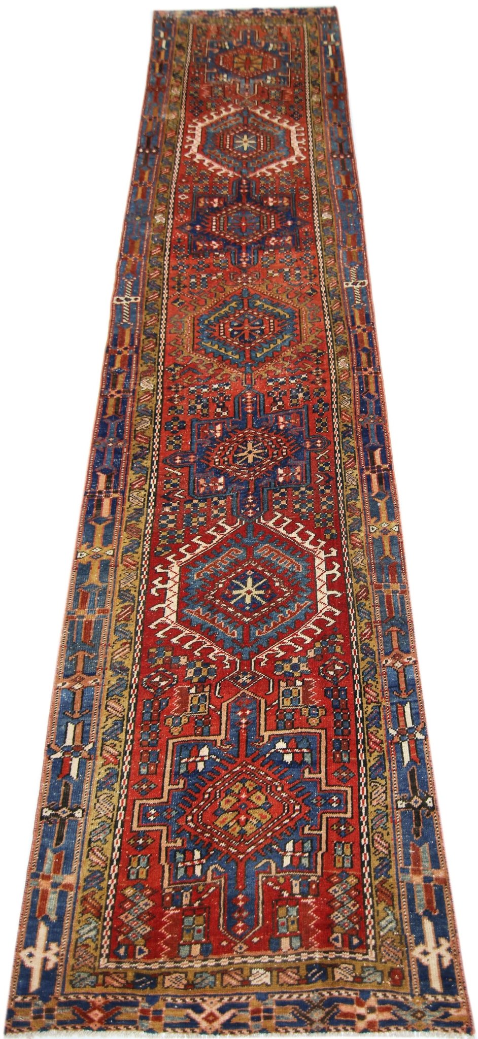 A vintage Persian Karaja runner featuring geometric medallions in red, blue, and cream wool.
