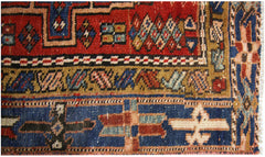 A vintage Persian Karaja runner featuring geometric patterns in red, blue, and tan wool.