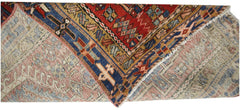A vintage Persian Karaja runner with a geometric red, blue, and tan wool pattern.