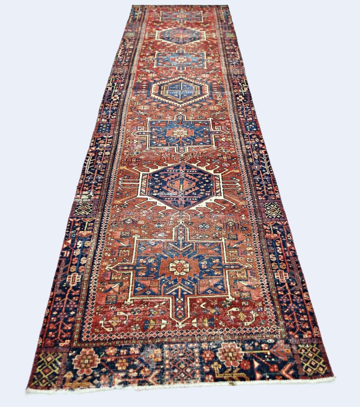 A vintage Persian Karaja runner featuring geometric medallions in red and blue wool.