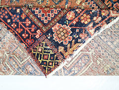 A vintage Persian Karaja runner featuring intricate geometric patterns in red, blue, and cream.