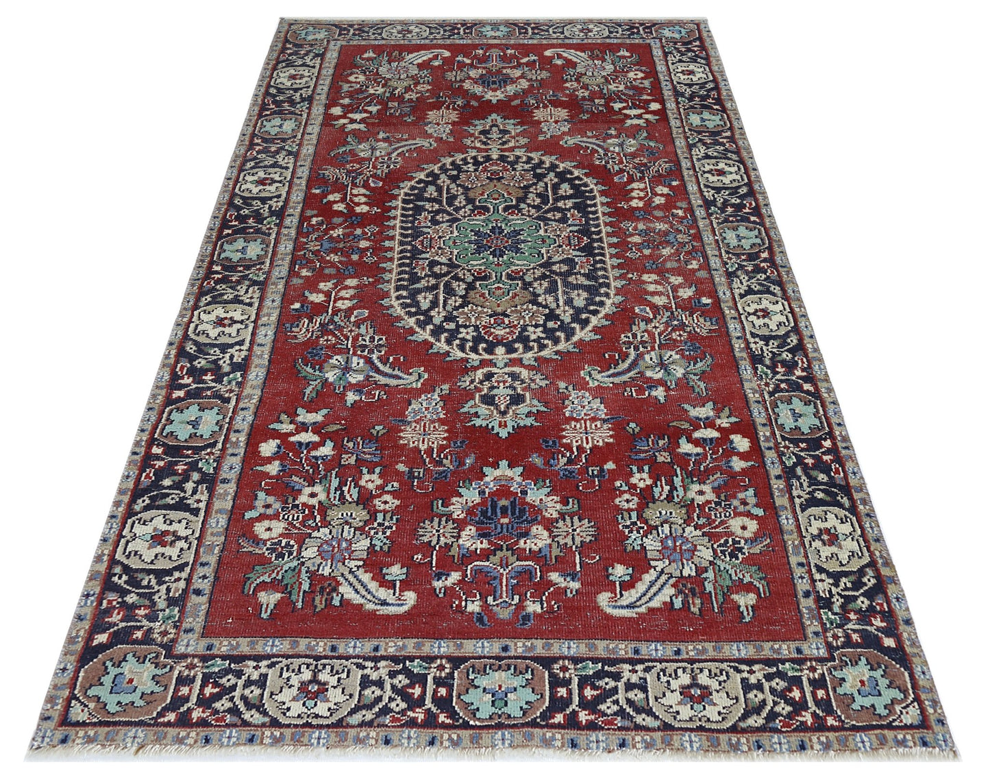 A vintage Persian Kashan rug featuring a central medallion and floral patterns on a red background.