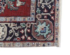 A corner detail of a vintage Persian Kashan rug featuring intricate floral patterns in wool.