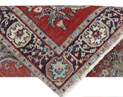 A corner view of a vintage Persian Kashan rug featuring intricate floral patterns in red and blue.