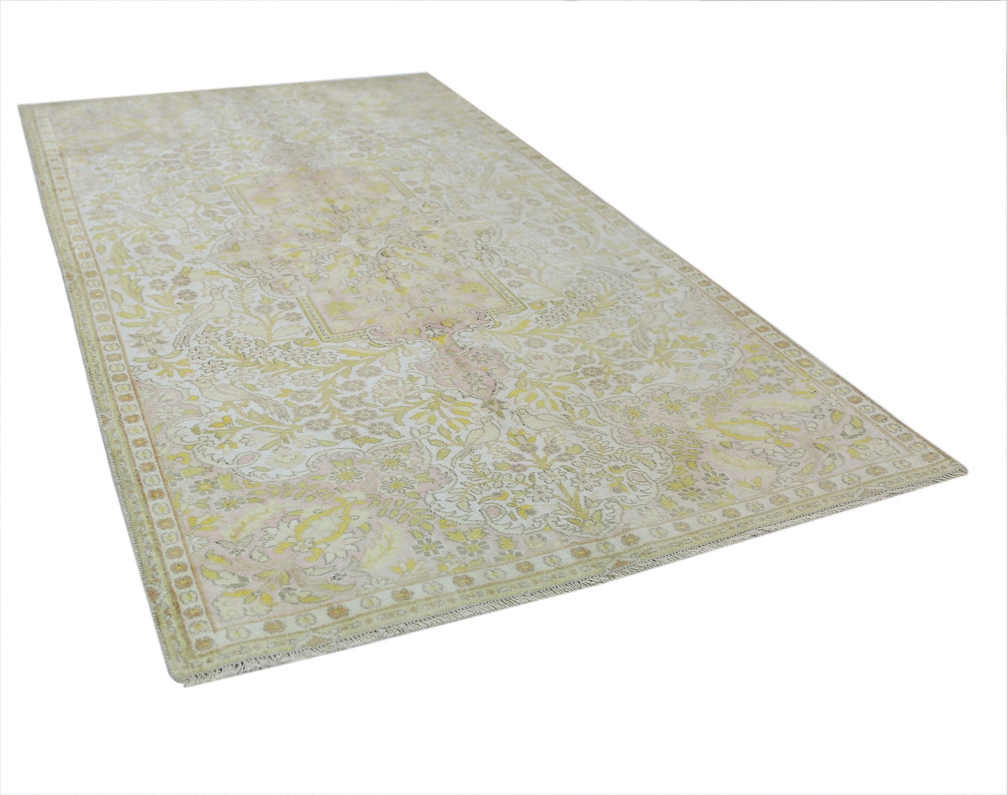 A vintage Persian Kashan rug featuring a faded floral pattern in soft yellow and cream tones.