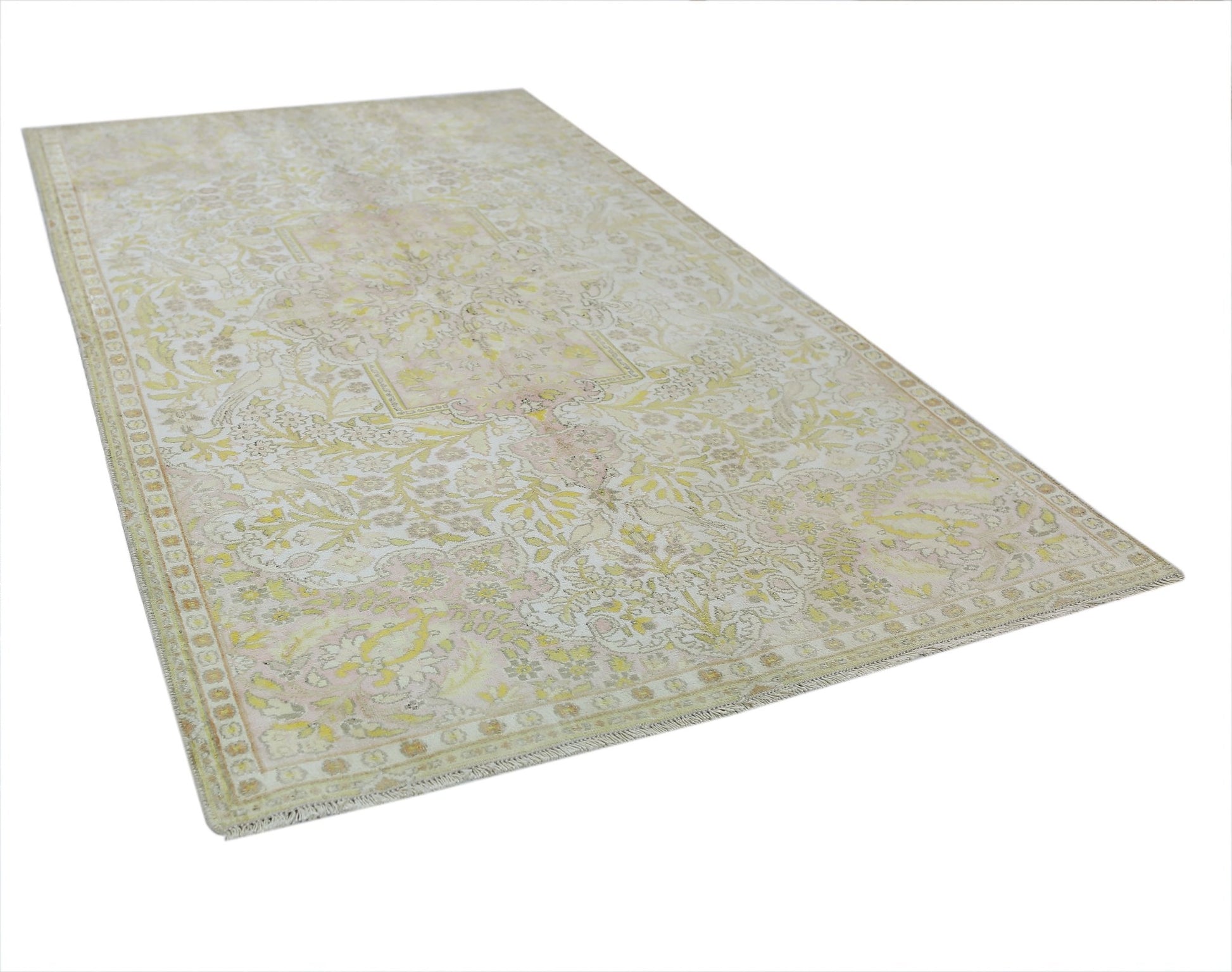 A vintage Persian Kashan rug featuring a faded floral pattern in soft yellow and cream tones.