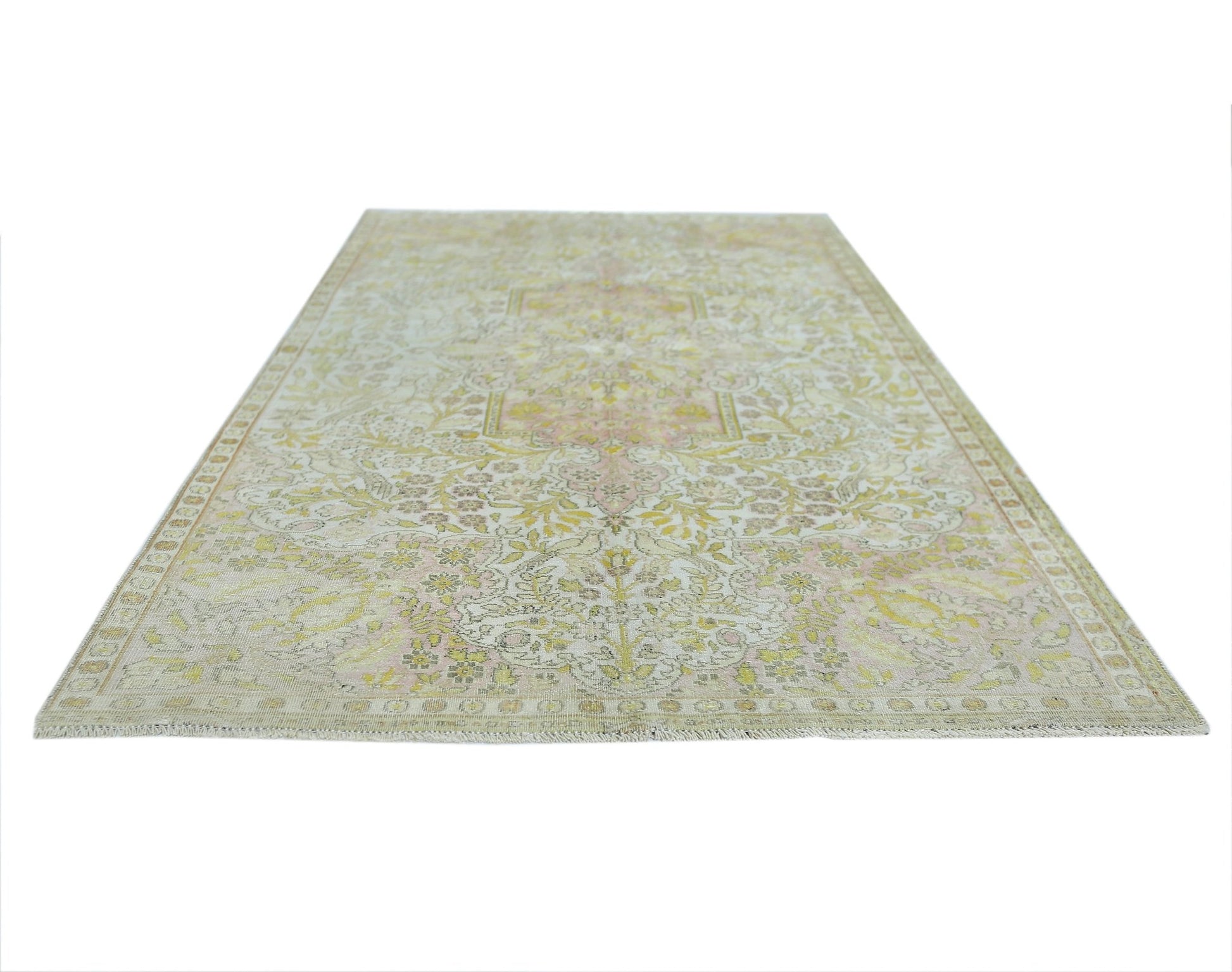 A vintage Persian Kashan rug featuring a faded floral pattern in soft yellow and pink tones.