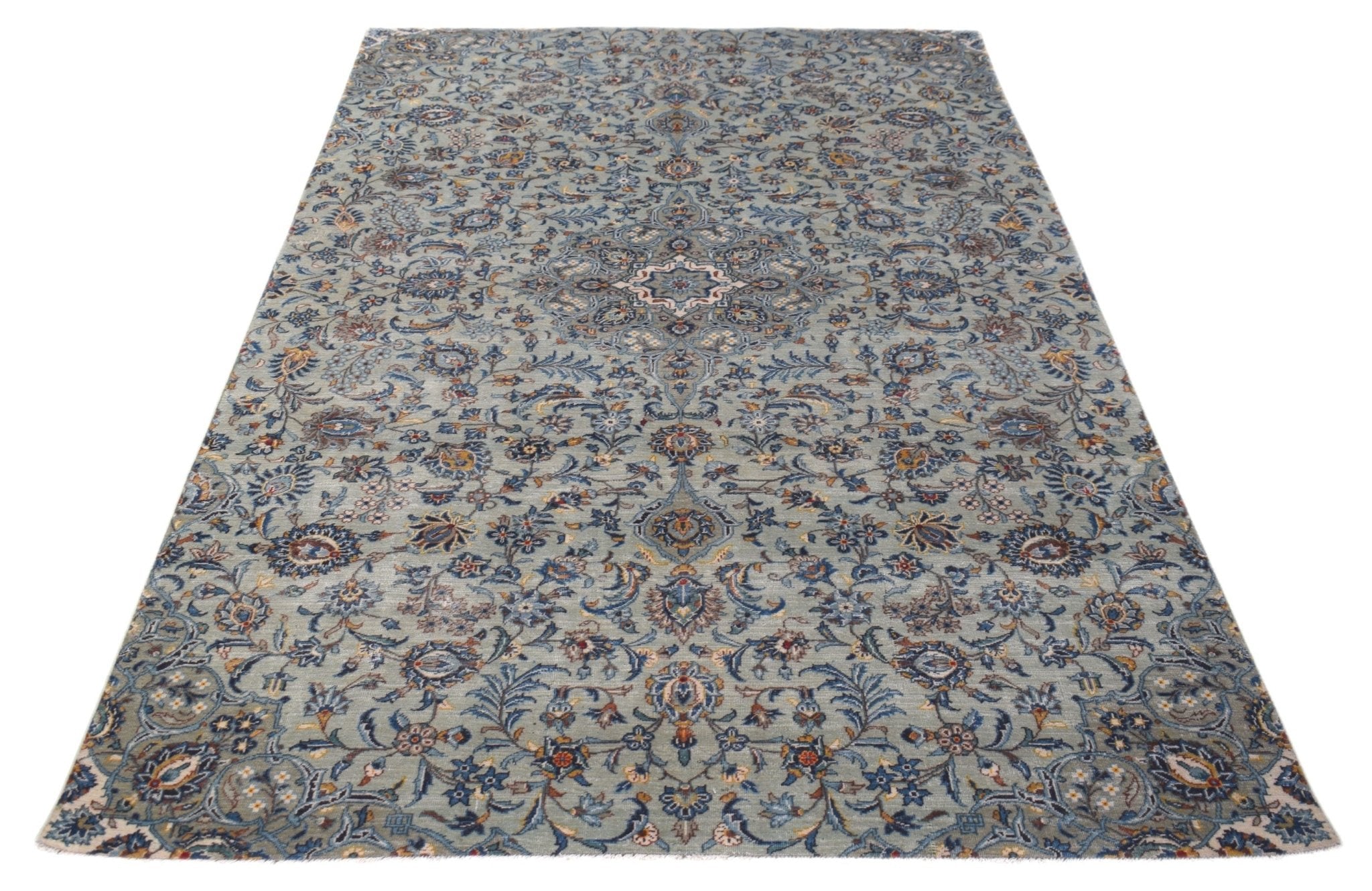A vintage handwoven Persian Kashan rug featuring intricate floral patterns in blue and cream tones.