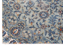 A vintage Persian Kashan rug featuring intricate floral patterns in blue and cream tones.