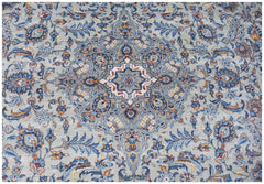 A vintage Persian Kashan rug featuring intricate floral patterns in shades of blue and cream.
