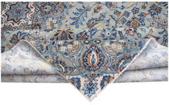 A vintage handwoven Persian Kashan rug featuring intricate blue and cream floral patterns.
