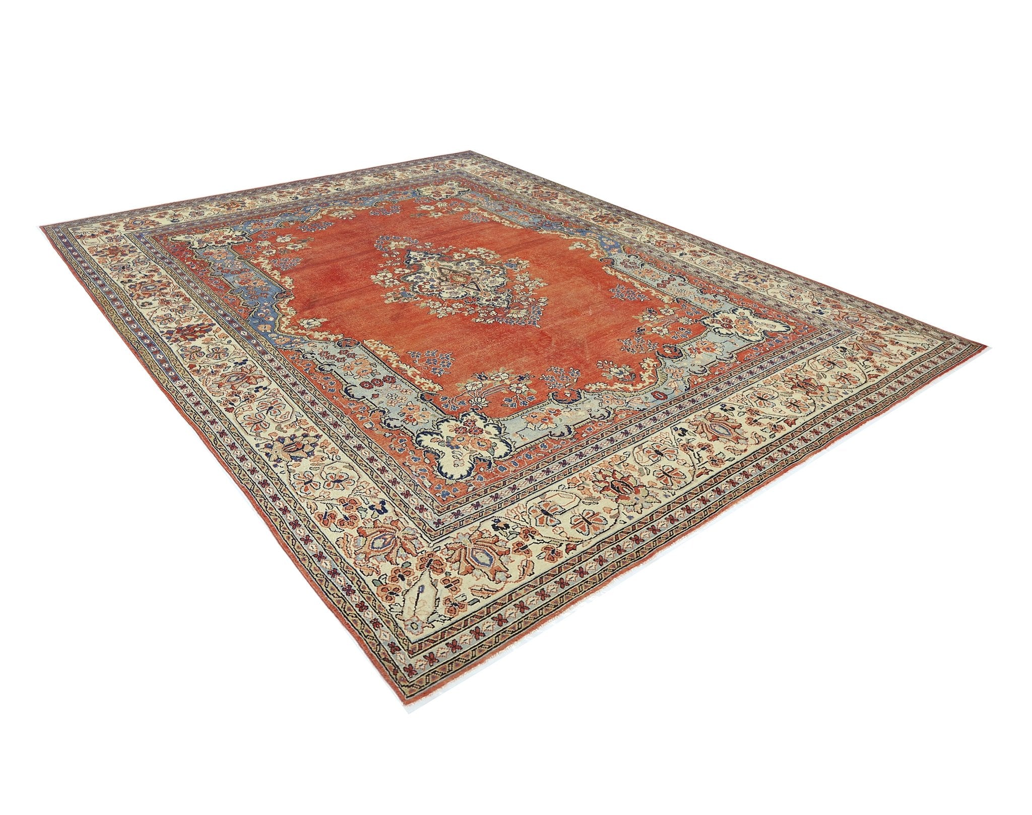 A vintage Persian Tabriz rug featuring a central floral medallion on a red field with blue borders.