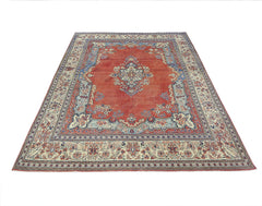 A vintage Persian Tabriz rug featuring a central medallion on a red field with floral borders.