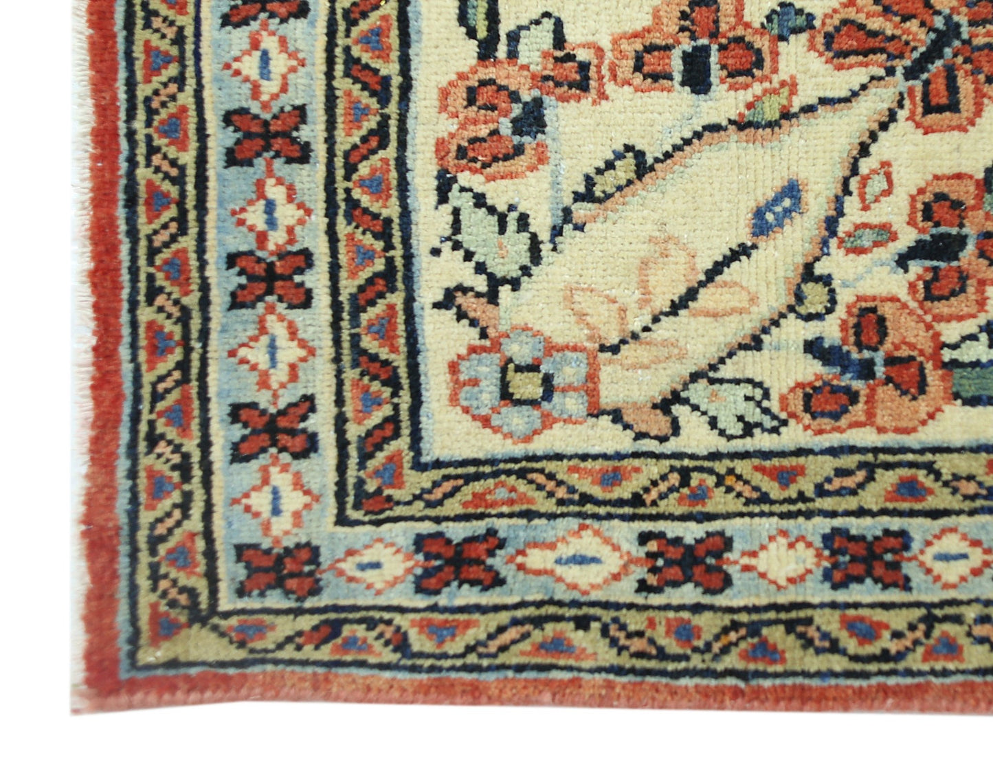 A corner view of a vintage Persian Tabriz rug featuring intricate floral patterns and borders.