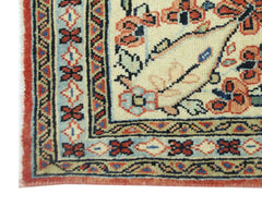 A corner view of a vintage Persian Tabriz rug featuring intricate floral patterns and borders.