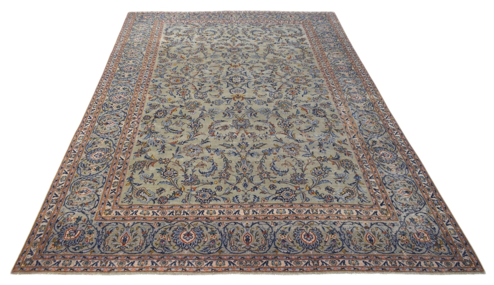 A vintage Persian Kashan rug featuring intricate floral patterns in blue and beige tones.
