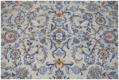 A vintage Persian Kashan rug featuring intricate floral patterns in blue, gold, and cream tones.
