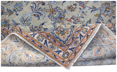 A vintage Persian Kashan rug featuring intricate floral patterns in blue, orange, and beige tones.