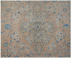 A vintage Persian Kashan rug featuring a central floral medallion in muted peach and blue tones.