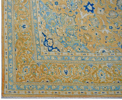 A vintage Persian Kashan rug featuring intricate floral patterns in shades of gold and blue.