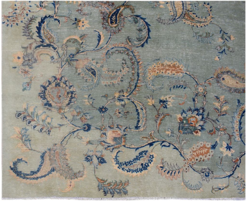 A vintage Persian Kashan rug featuring intricate floral and paisley patterns in blue and tan.