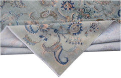 A vintage Persian Kashan rug featuring intricate floral patterns in blue and beige tones.
